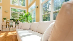 A living room couch surrounded by big windows that let light in thanks to residential window cleaning